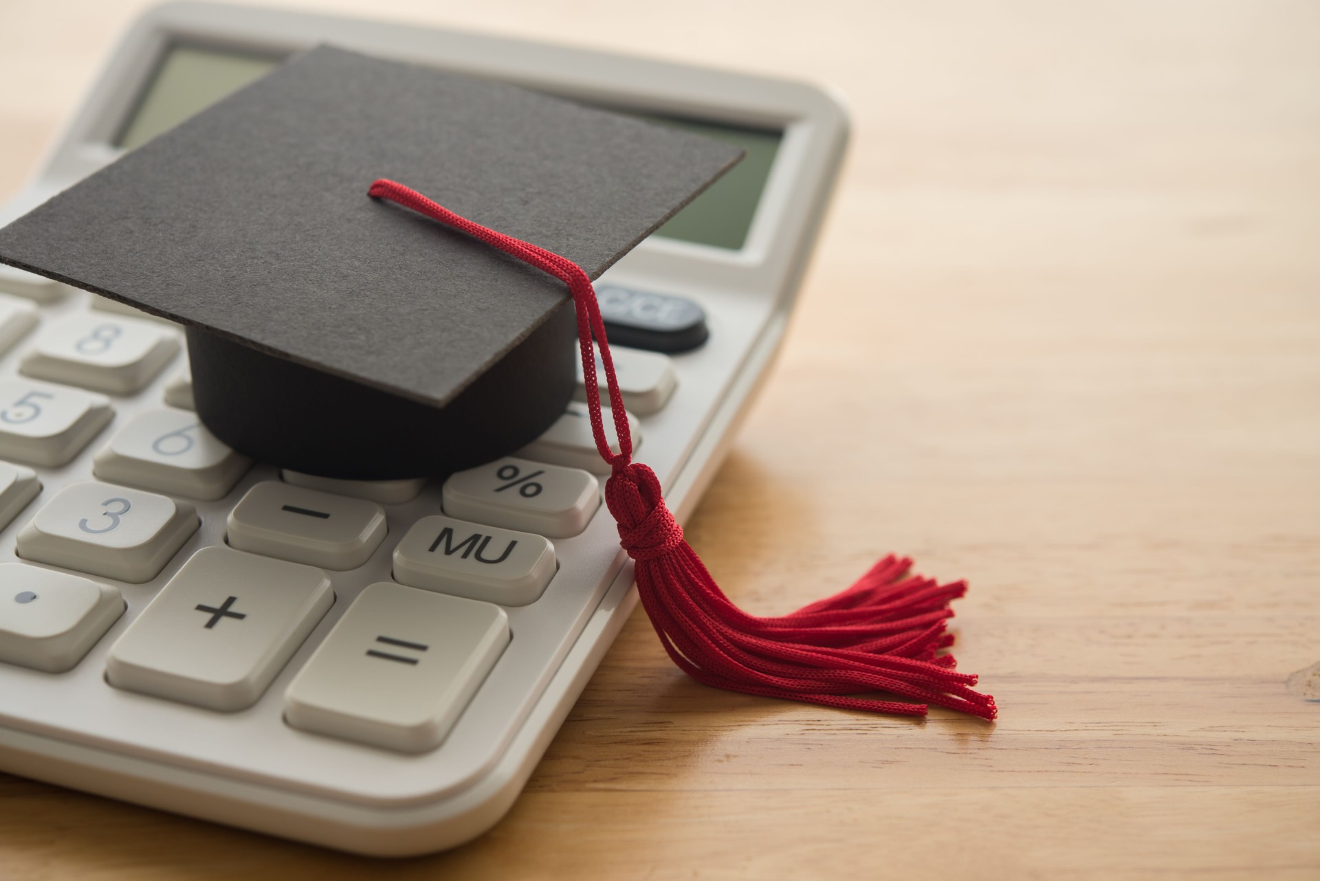 Mortarboard on white calculator.